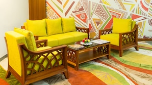 A living room with a sofa, two armchairs, a coffee table, and a patterned rug. - Viva Hotel (Margao)