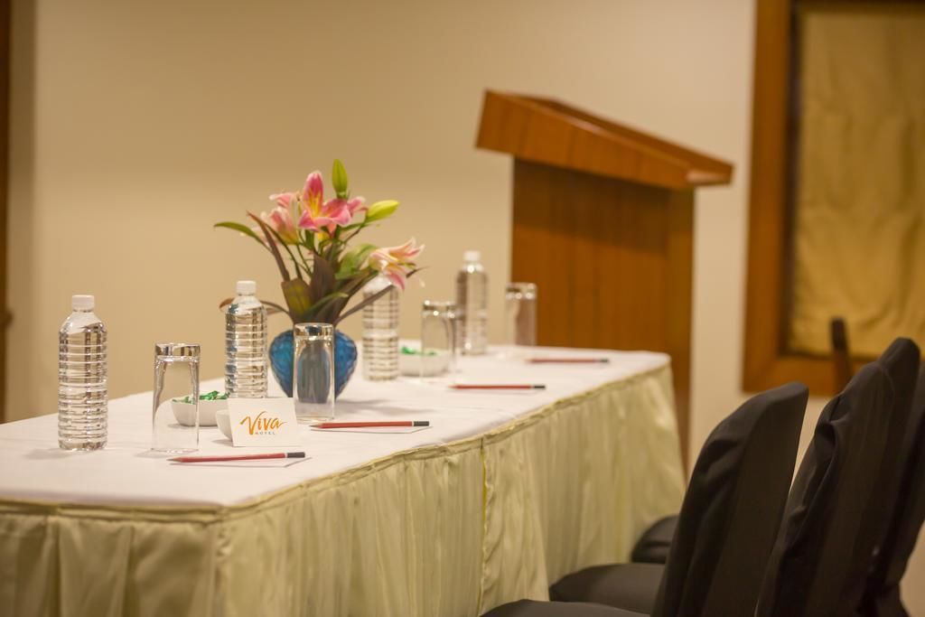 A conference table with water bottles, pens, and a name card labeled "Viva."