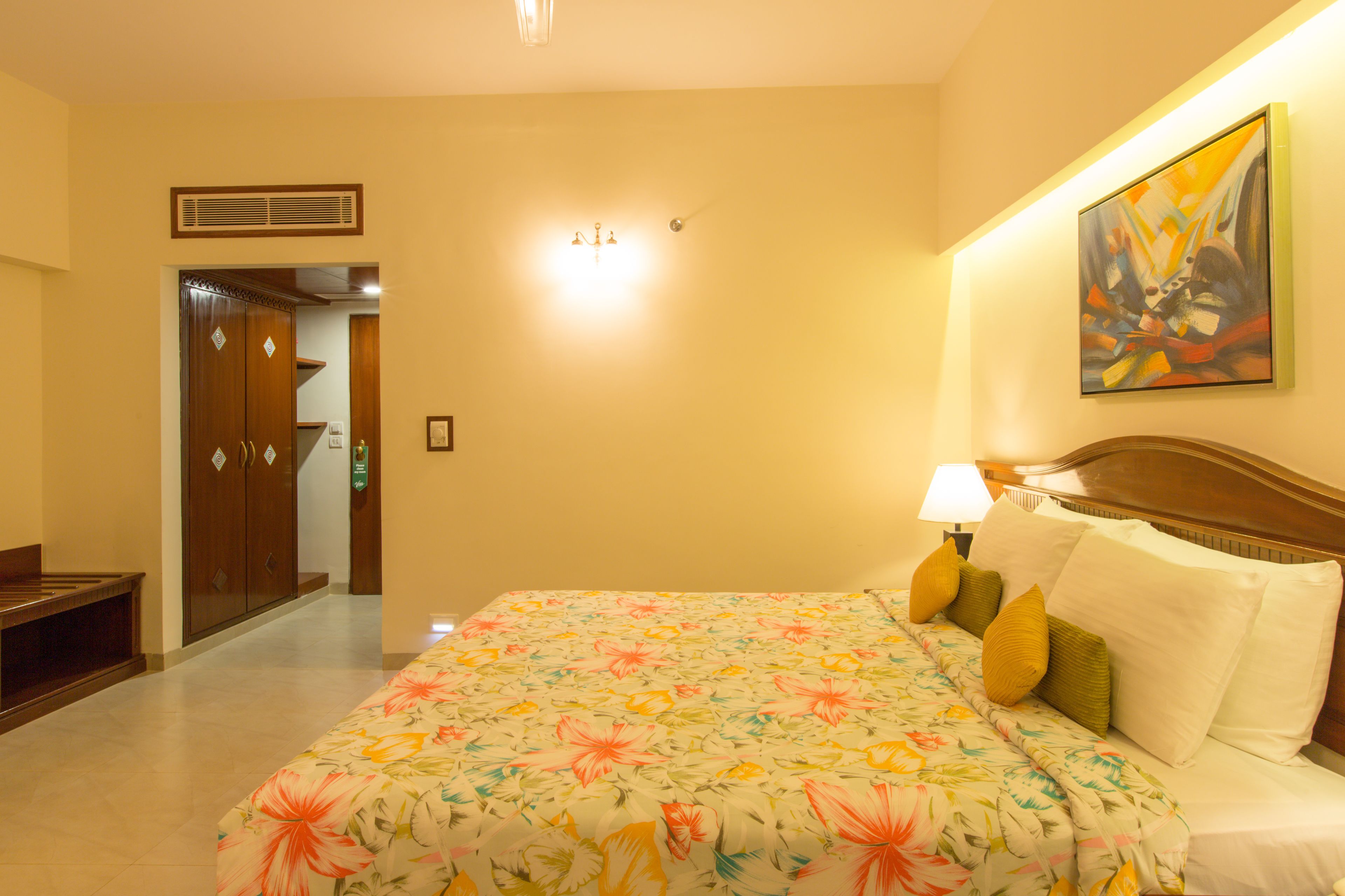Une chambre d’hôtel avec un lit, une table de chevet, une lampe et un tableau au mur.