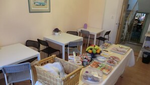 A dining area with a buffet setup, including a variety of food items and a fruit bowl. - Orbis (Prague)