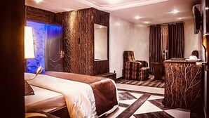 Una habitación de hotel con cama, una silla, un escritorio y un baño con espejo.