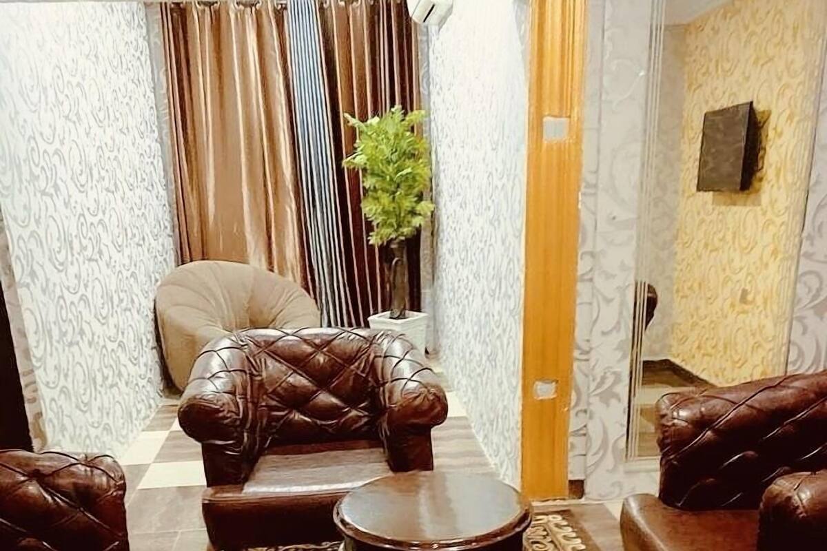A living room with a patterned rug, leather sofas, and a small table.