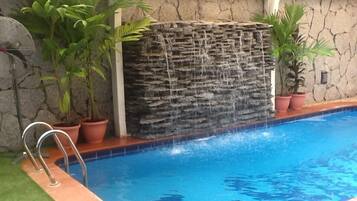 Una piscina cubierta, una piscina al aire libre de temporada, sombrillas