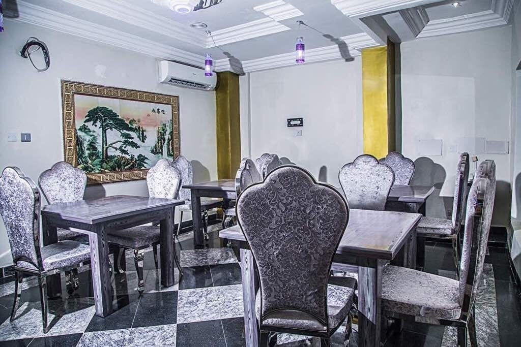 A conference room with a checkered floor, patterned chairs, a painting on the wall, and a yellow accent wall.