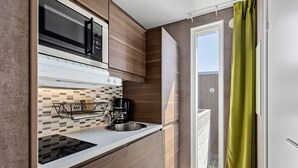 A modern kitchen with a microwave, stove, and sink. - First Camp City Strömstad (Stromstad)