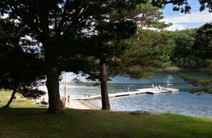 A lakeside park with a dock, trees, and a grassy area. - First Camp City Strömstad (Stromstad)