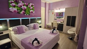 Een moderne hotelkamer met een groot bed, een kaptafel met spiegel en een zithoek.