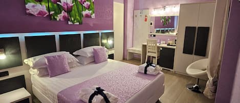 Deluxe kamer | Luxe beddengoed, een minibar, een kluis op de kamer, een bureau