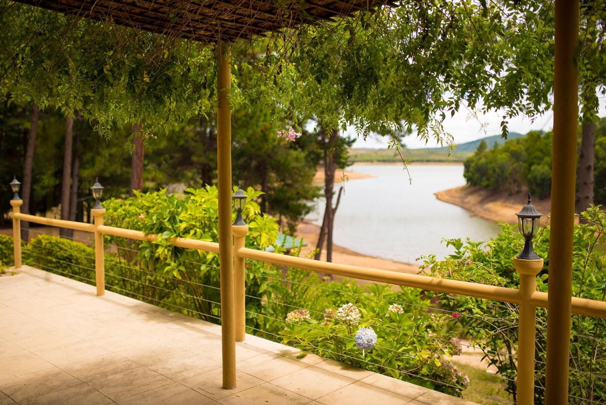 Un espace extérieur abrité, doté d’une rambarde, de verdure et offrant une vue sur un lac.