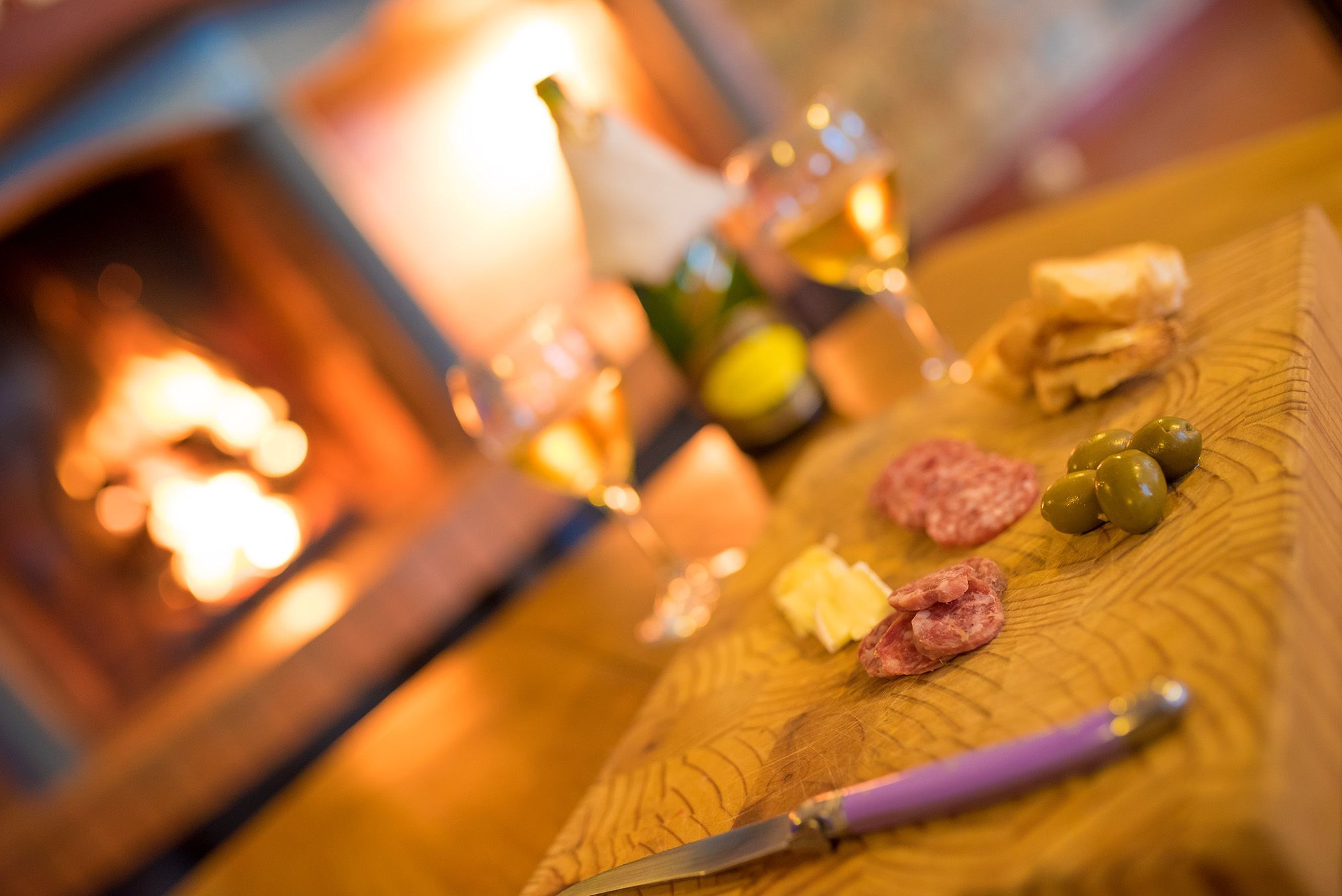A wooden table with food items and a knife.