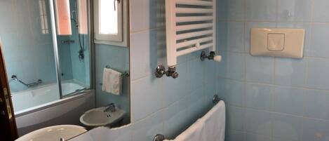 A bathroom with a sink, mirror, and shower.
