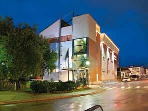 A modern hotel with a glass facade, a visible staircase, and a well-lit entrance. - Hotel Dal Ponte (Bassano del Grappa)