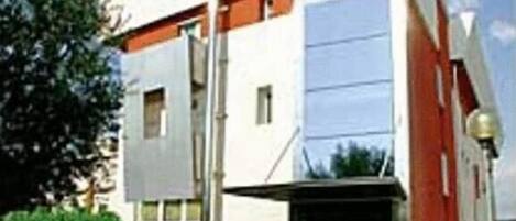 Un edificio moderno con techo plano, ventanas grandes y una pared de acento roja.