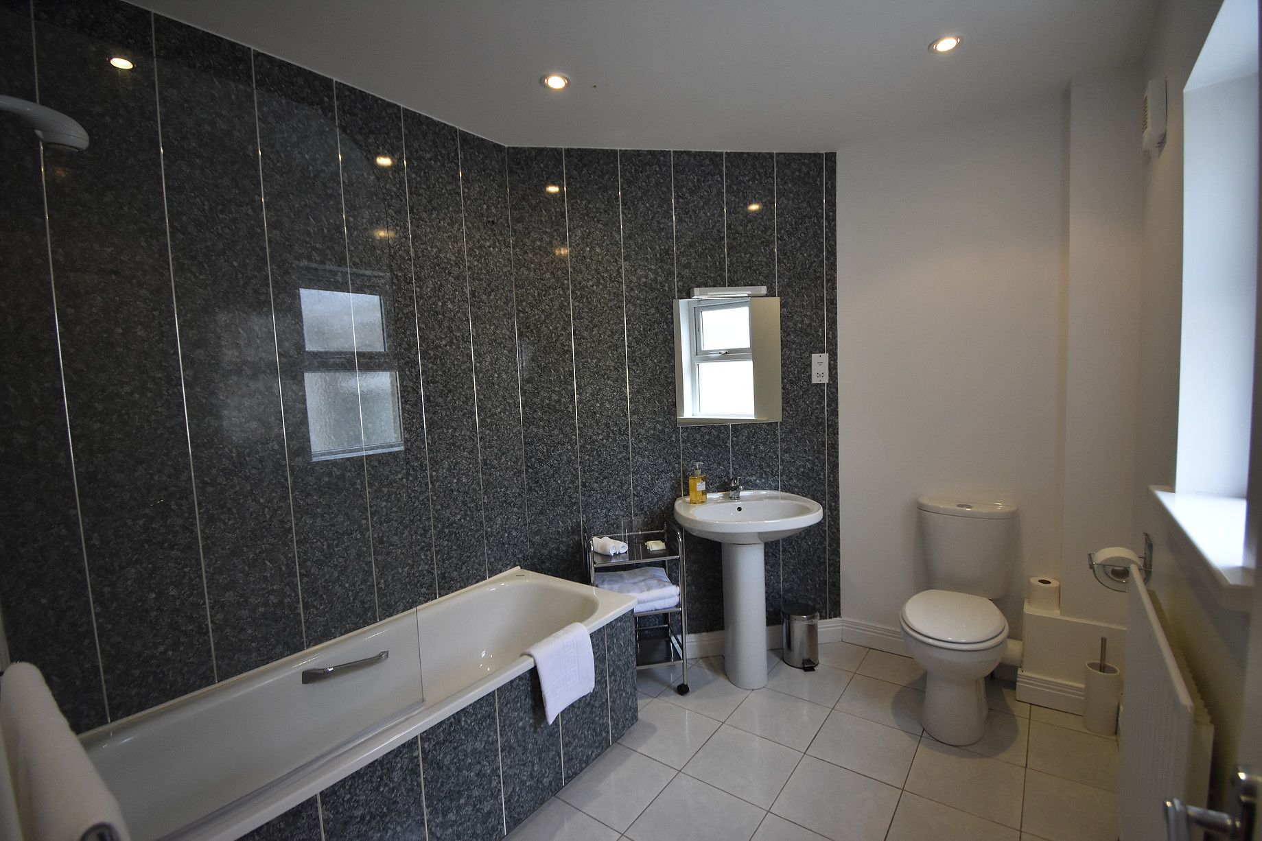 A modern bathroom with a bathtub, sink, and toilet.