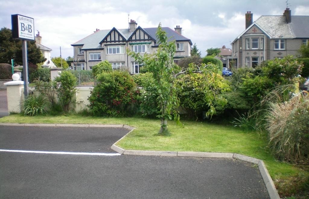 A residential street with houses, a B&B sign, and a date stamp.
