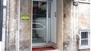 Een hotelingang met een bord waarop 'HOTEL PARM' staat.