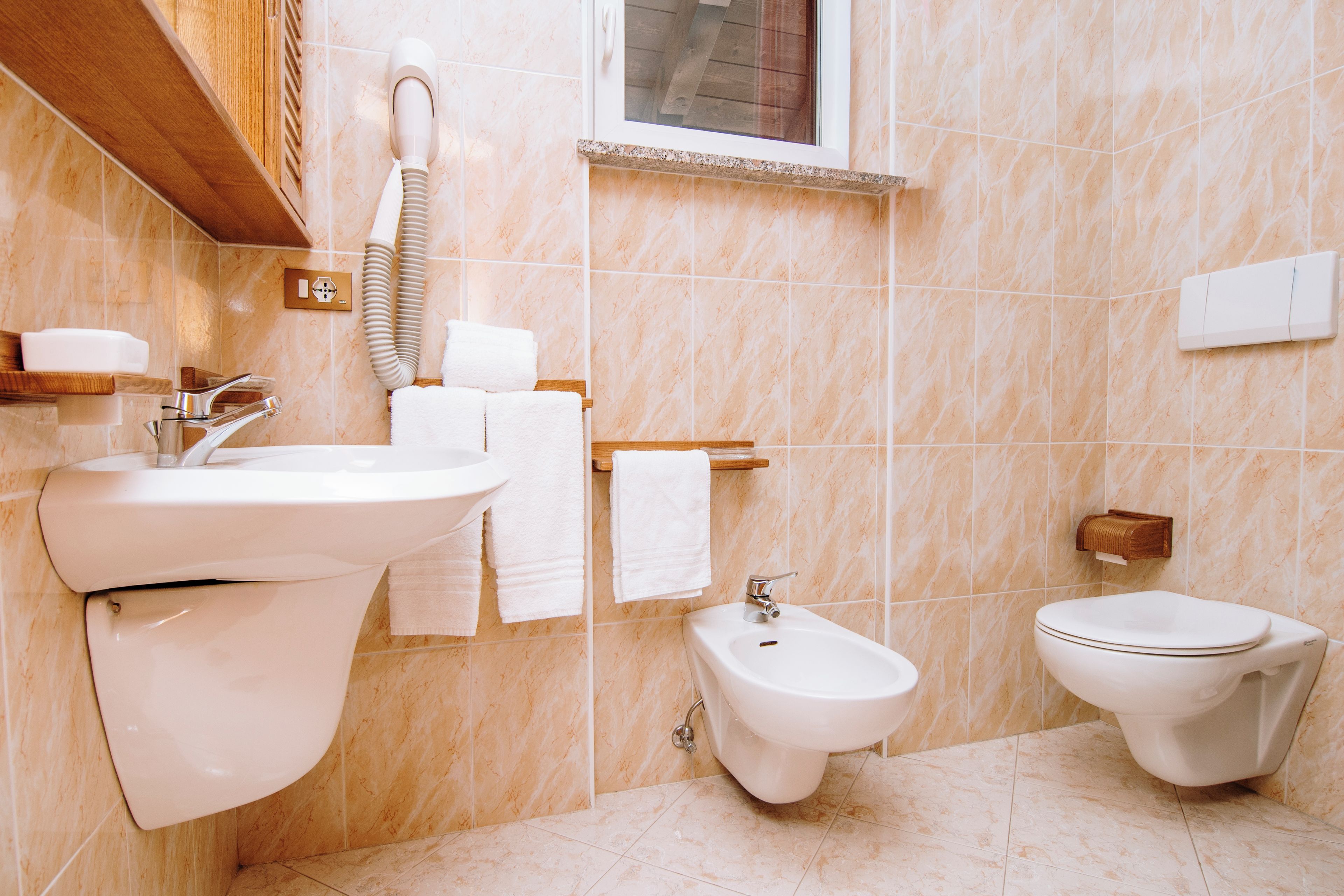 Et badeværelse med vask, bidet og toilet.