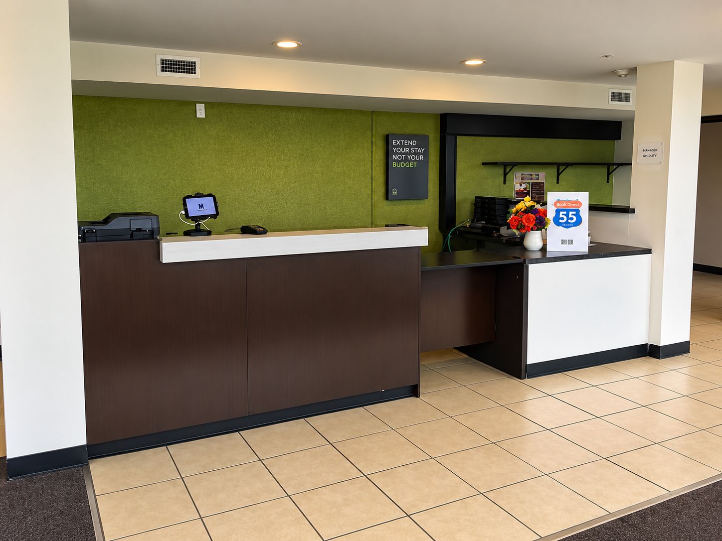 A reception desk with a computer monitor, a cash register, and a sign indicating a 55% discount.