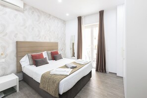 A modern hotel room with a large bed, a bedside table, and a view of the outside. - 247 LuxuryRooms (Rome)