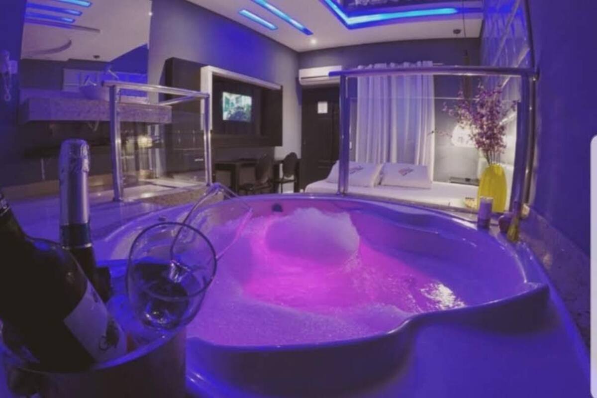 Une salle de spa moderne équipée d’un jacuzzi, d’un coin salon et d’un téléviseur.