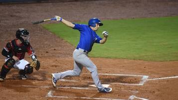 Un jugador de béisbol en pleno swing durante un partido.