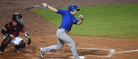 Un jugador de béisbol en pleno swing durante un partido.