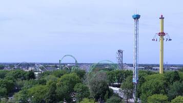 A roller coaster with a tall tower and a green arc structure in the background.