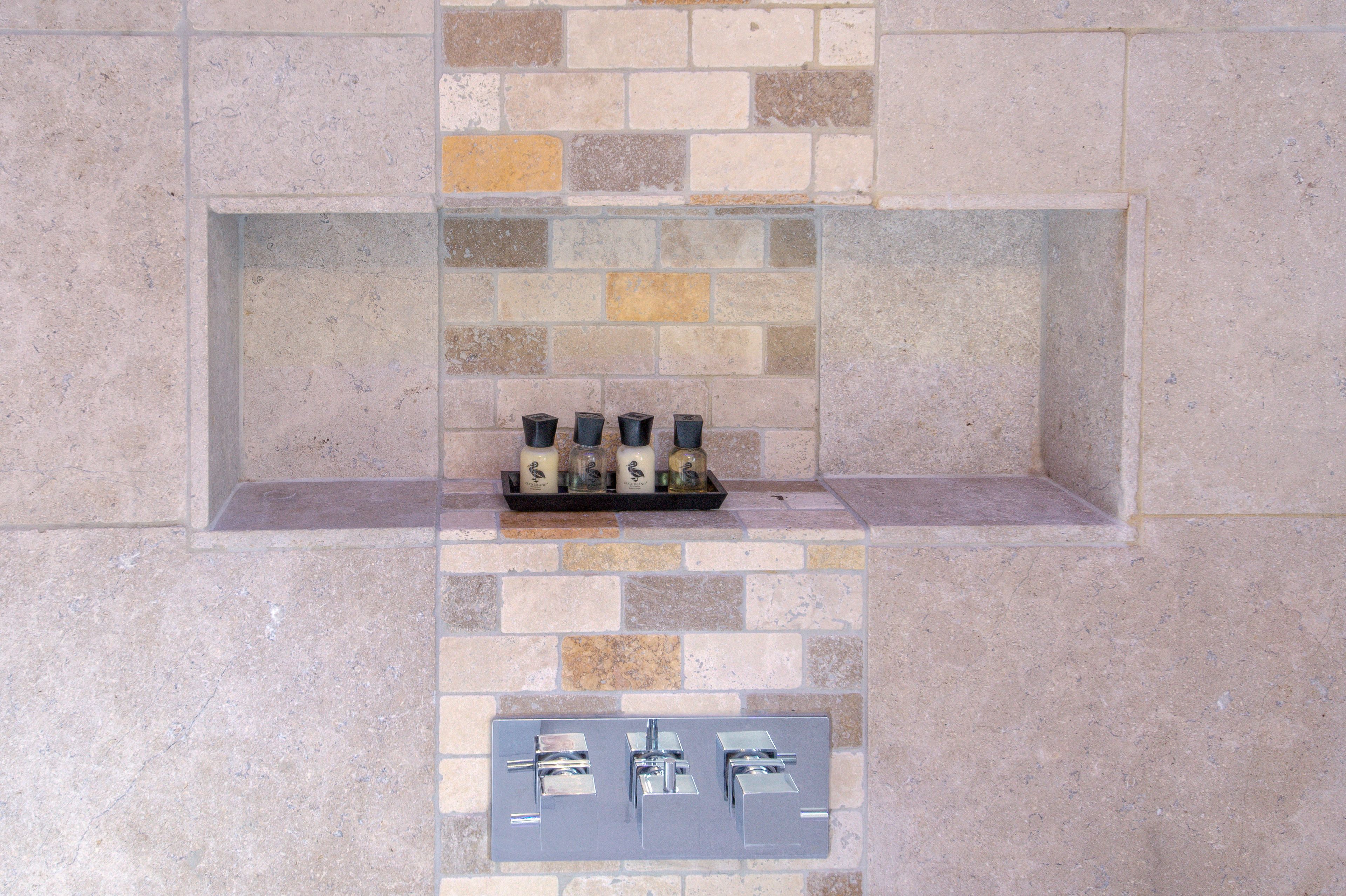Una chimenea de piedra con un panel de control debajo.