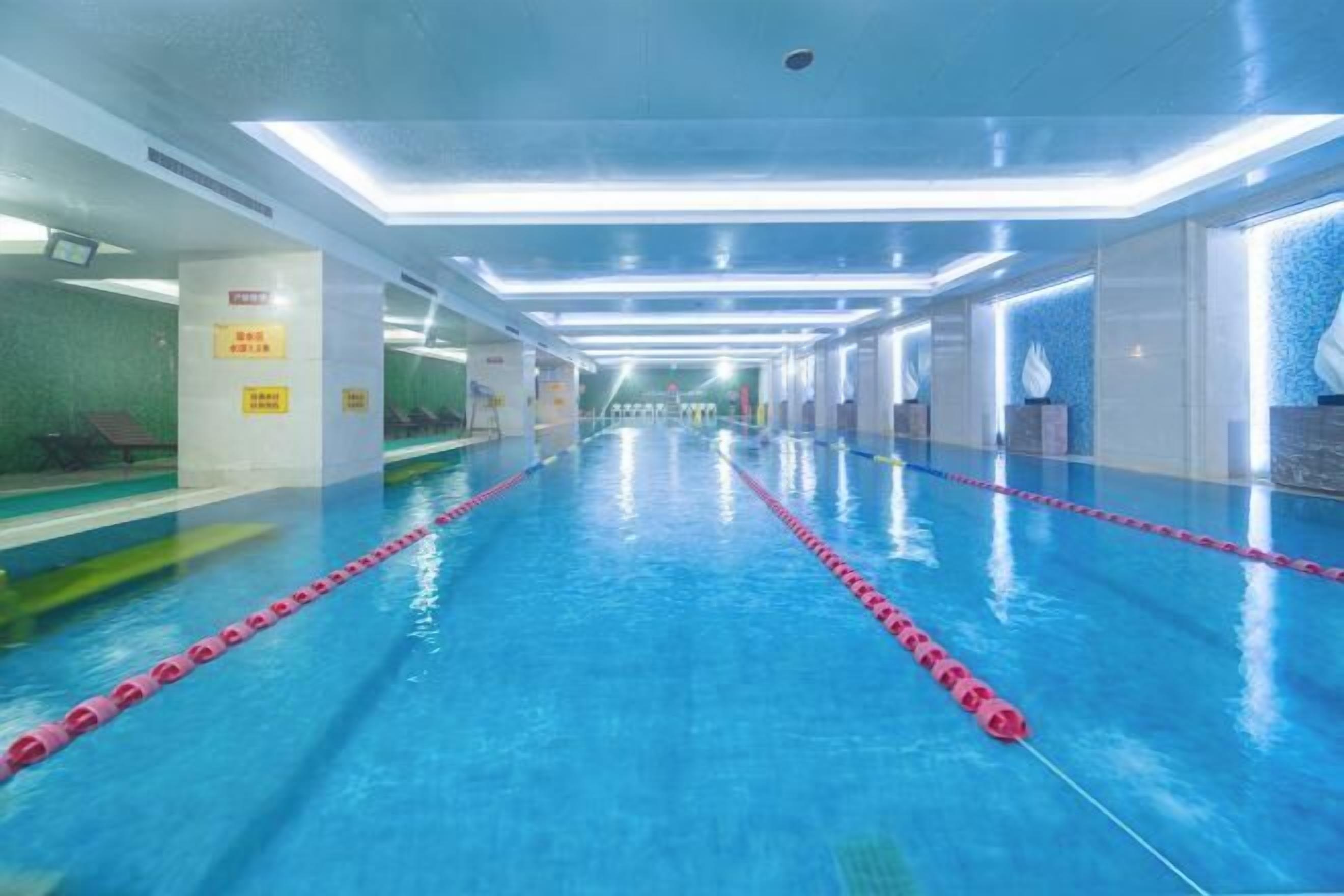 A swimming pool with clear lane dividers and a modern, well-lit interior.