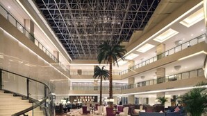 A multi-level hotel lobby with a modern design, featuring a central atrium, multiple seating areas, and a staircase. - Nanxiang Hotel (Anqing)