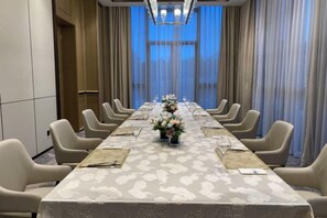 A conference room with a long table, chairs, and floral centerpieces. - Yancheng Guest Hotel (Yancheng City)