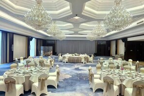 A banquet hall with round tables, white chairs, and chandeliers. - Yancheng Guest Hotel (Yancheng City)