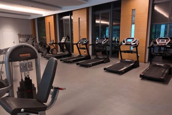 A gym with treadmills, elliptical machines, and weightlifting equipment. - Yancheng Guest Hotel (Yancheng City)