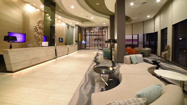 A spacious lobby with a reception desk, seating area, and large windows. - Mercure Selangor Selayang (Batu Caves)