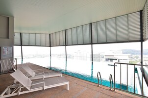 An indoor swimming pool with a view of the city.