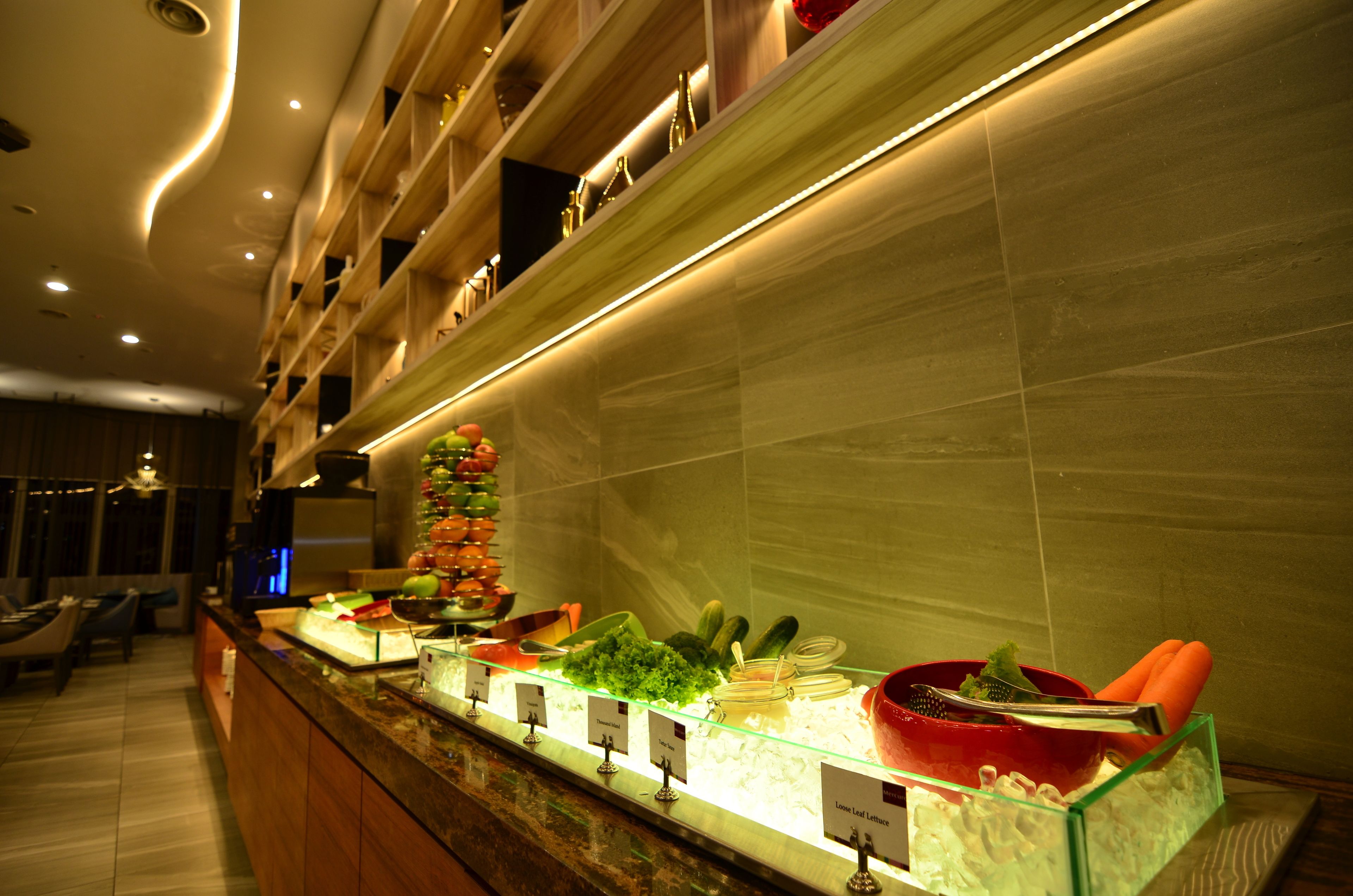 A buffet area with various food items and utensils.
