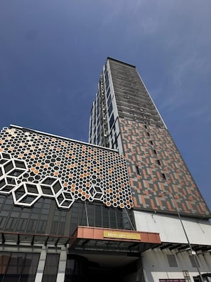 Un edificio alto con una fachada distintiva que presenta patrones geométricos y un cartel del Hotel Mercure.