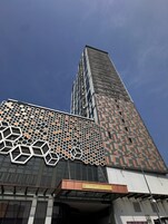 A tall building with a distinctive facade featuring geometric patterns and a sign for the Mercure Hotel.