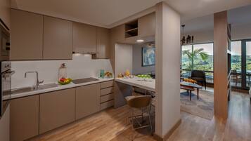 A modern kitchen with a large island, built-in appliances, and a dining area with a view.
