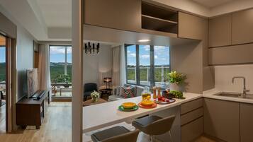 Cocina moderna con un ventanal grande, comedor y vistas a zonas verdes y un puente.