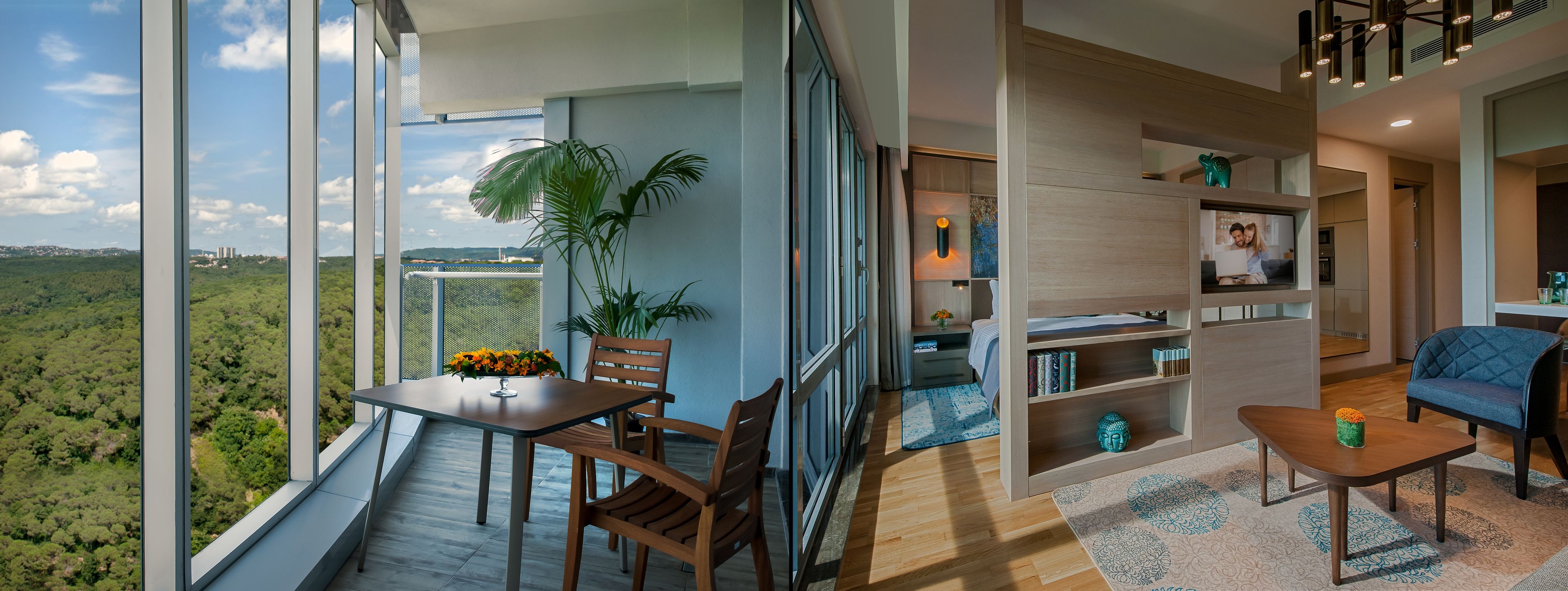 A modern living room with a large window overlooking a forested area, a dining area with a table and chairs, and a cozy seating area with a sofa and a small coffee table.