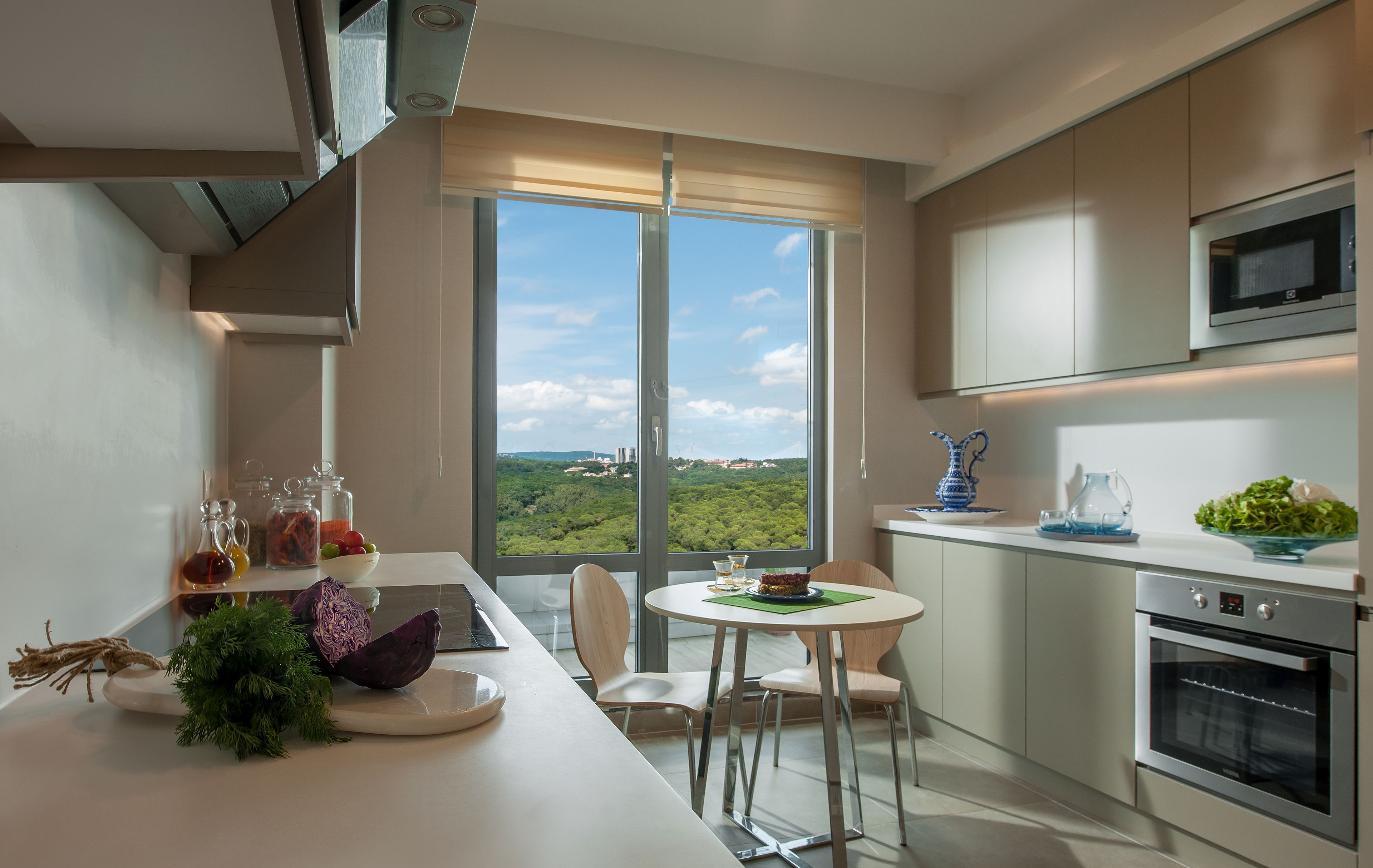 Eine moderne Küche mit großem Fenster, einem Essbereich und einem Einbauofen.