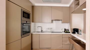 A modern kitchen with built-in appliances, a sink, and bar stools.