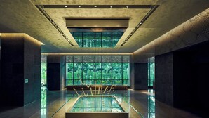 A modern interior with a central glass table, large windows, and a high ceiling. - THE AMNIS, a Luxury Collection Hotel, Kaohsiung (Kaohsiung)