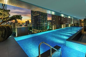 Una piscina al aire libre, tumbonas