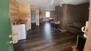 Une chambre compacte et moderne, dotée d’une kitchenette, d’un coin repas et d’un espace salon.