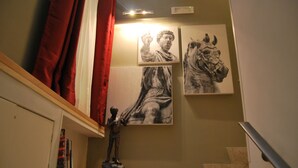 A staircase with a statue of a child and two paintings on the wall. - Navona Residenza de Charme (Rome)