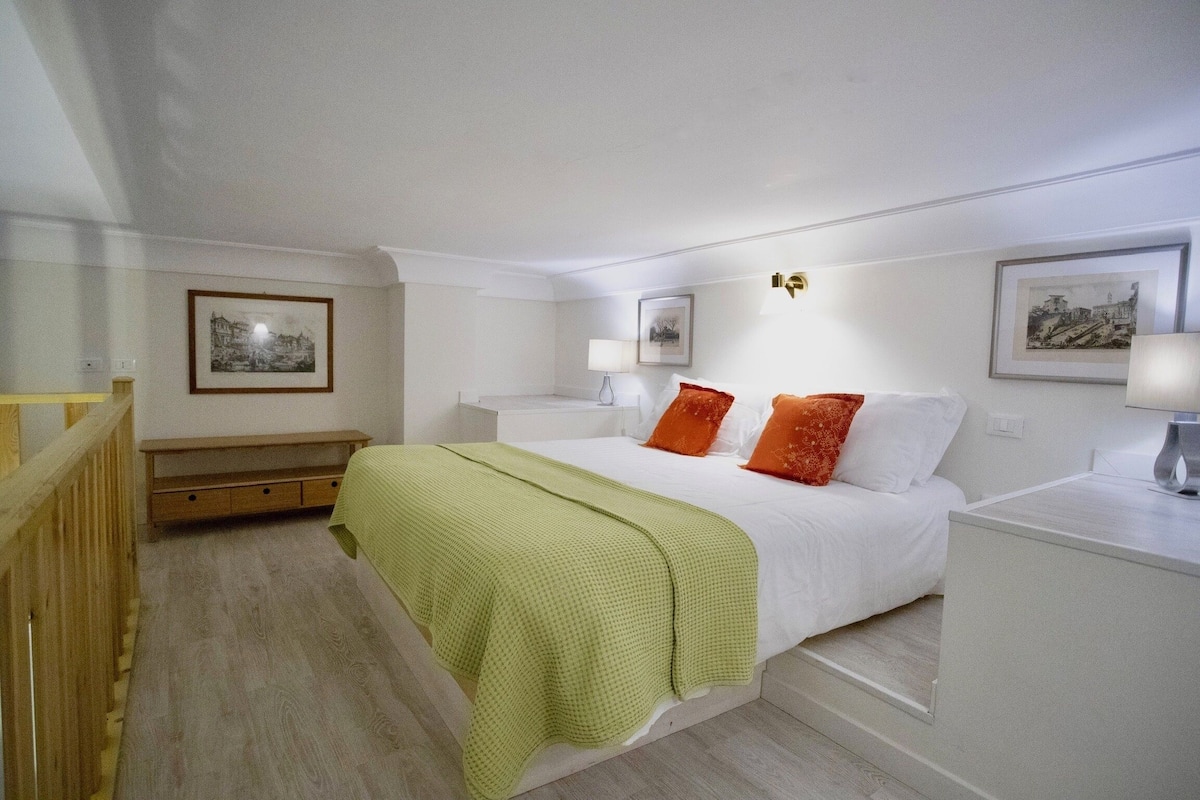 A bedroom with a bed, bedside tables, and a wooden bench.