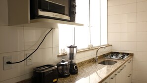A kitchen with a microwave, toaster, blender, and gas stove. - Rio045 - Apartment Ipanema (Rio de Janeiro)