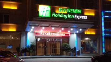 Entrada de un hotel Holiday Inn Express con señalización iluminada y puerta de cristal.